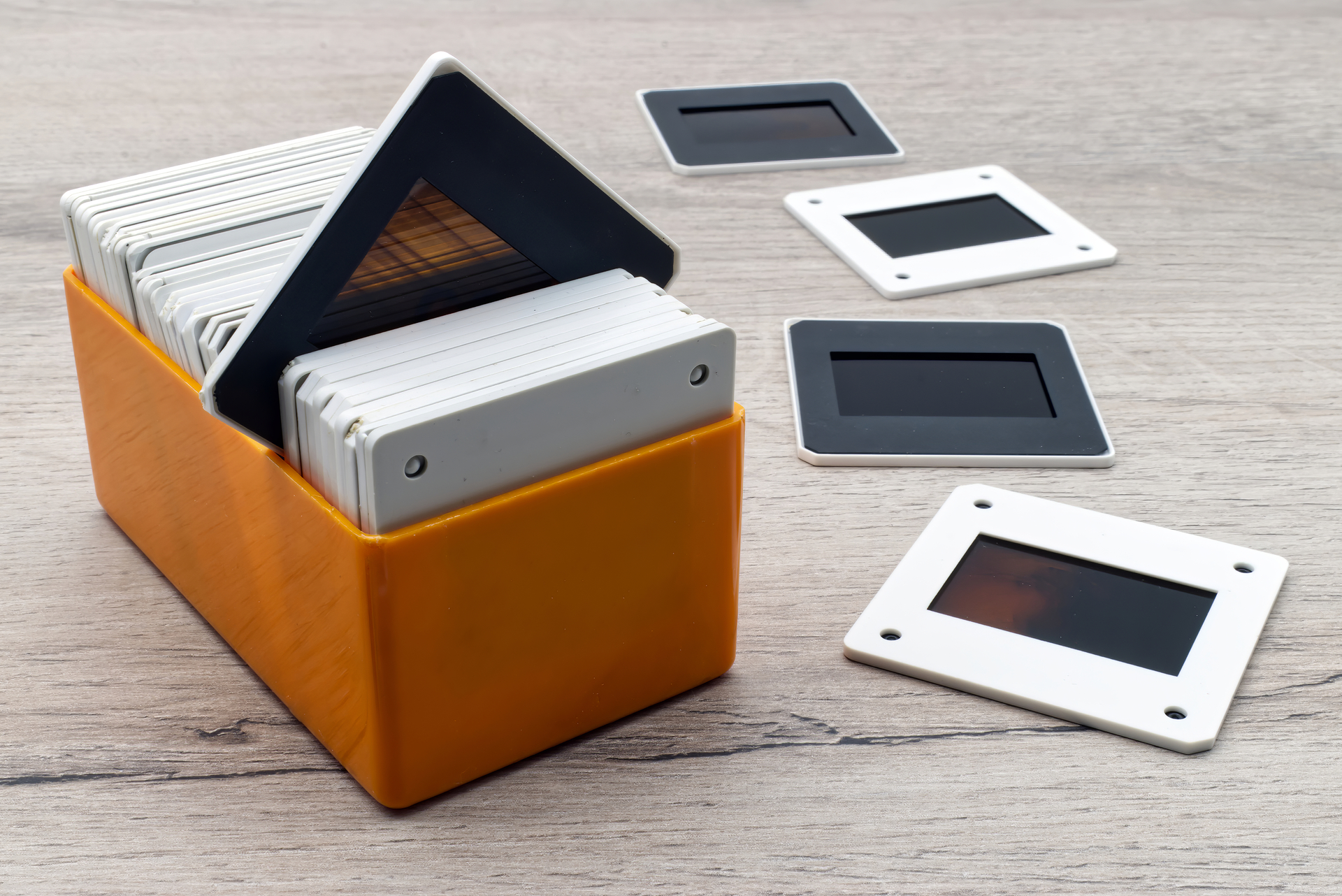 Old slides in a plastic box. Vintage 35mm slide film on wooden table.